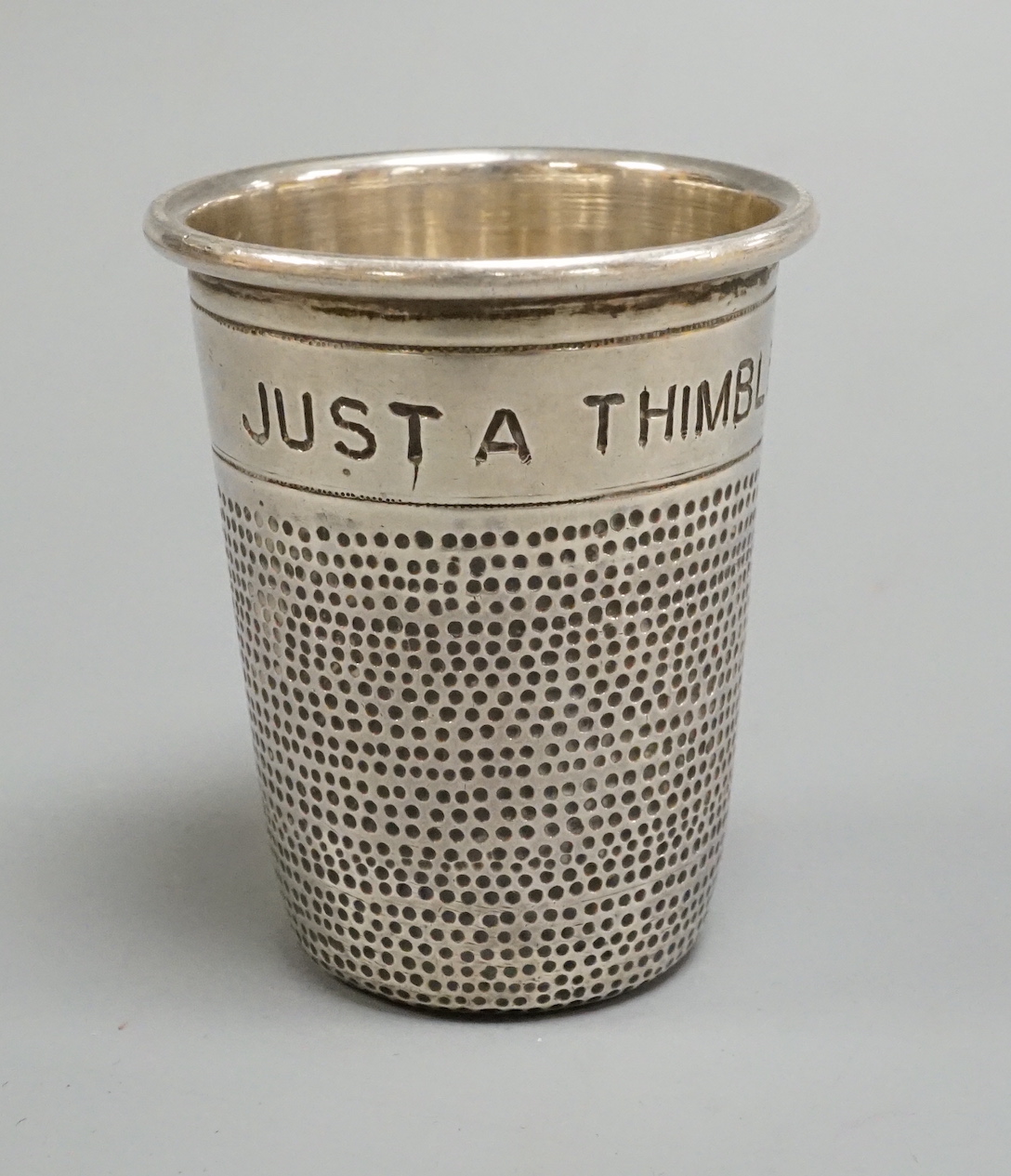 A sterling 'Just a Thimbleful' tot, stamped K.P.D, 51mm.